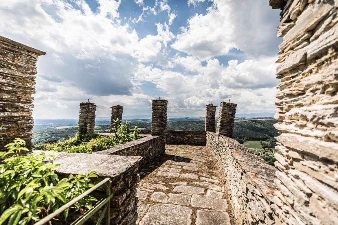 Eine zur Terrasse umgewandelte Burgbastion, Steinmauern und blauer Himmel